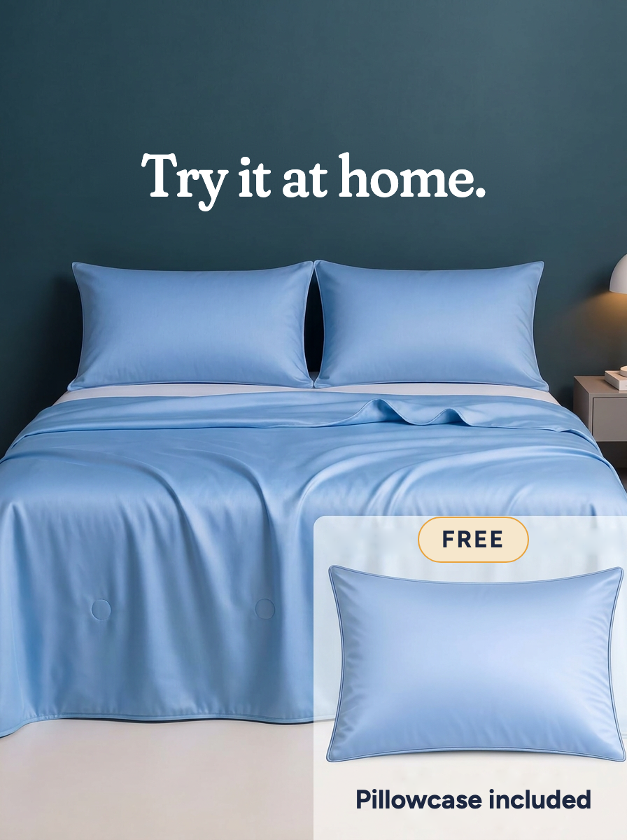 The Cooling Comforter in Frost Blue on a made bed · Try it at home · Free · Pillowcase included