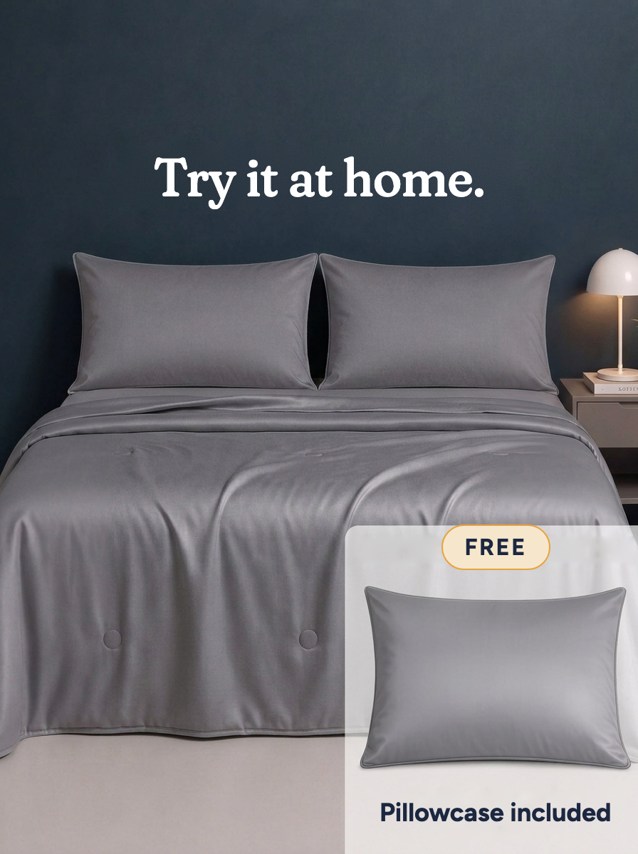 The Cooling Comforter in Frost Gray on a made bed · Try it at home · Free · Pillowcase included