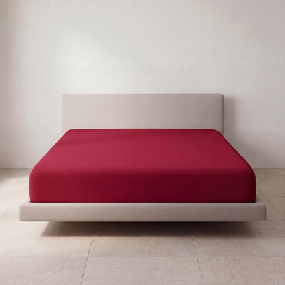 The Fitted Sheet in Fireside Red on a mattress